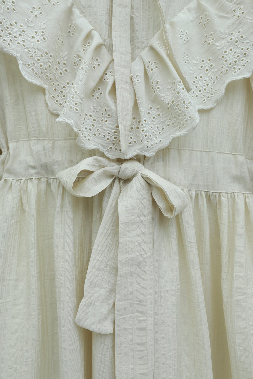 Robe en crinkle avec doublure, col et taille à nouer et détail à œillets